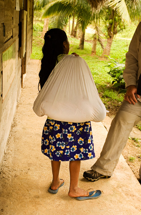 BagOBaby_2514.jpg - A young Mayan girl is talking to Richard Bernabe who is asking her to put down her bundle so he can take her picture.